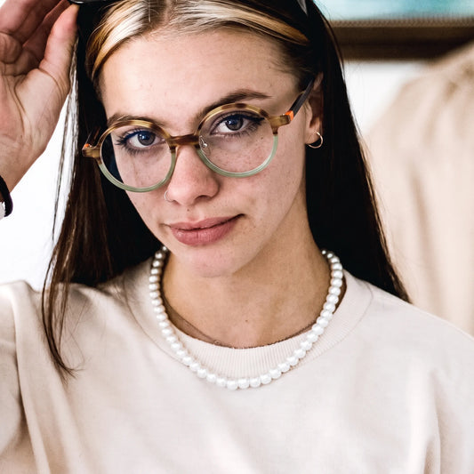 Model wearing Barledear Frosted Sage Tortoise round acetate eyeglasses in a lifestyle portrait showing the lightweight frosted frame fit
