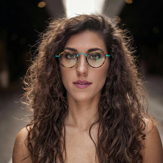 Model wearing Barledear Sunlit Teal Tortoise eyeglasses in a lifestyle portrait with colorful geometric frame styling