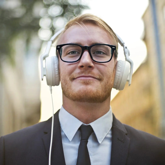 man wearing VoyueLens KA62 black frame eyeglasses while listening to music with over-ear headphones