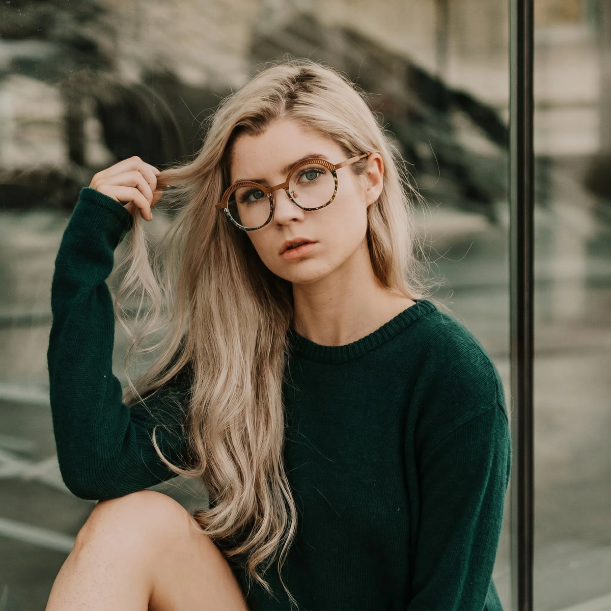 Model wearing Barledear Amber Mosaic eyeglasses in a lifestyle portrait with warm artistic titanium frame styling