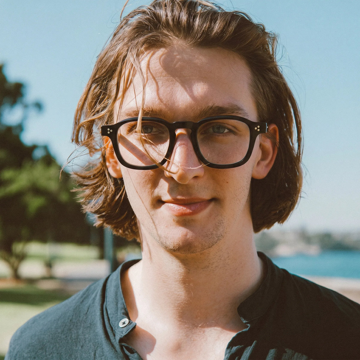 model wearing Barledear Charcoal Noir eyeglasses in a lifestyle portrait with retro square acetate frame