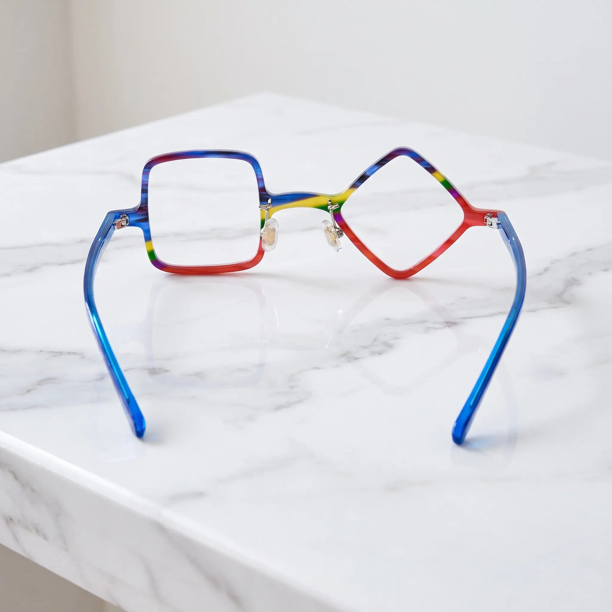 Barledear Cobalt Crimson asymmetric geometric acetate eyeglasses back view showing the mismatched geometric shapes, clear nose pads, and cobalt-blue temple structure.