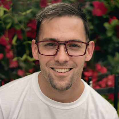 Model wearing Barledear Crimson Noir eyeglasses in a lifestyle portrait with lightweight square titanium frame styling