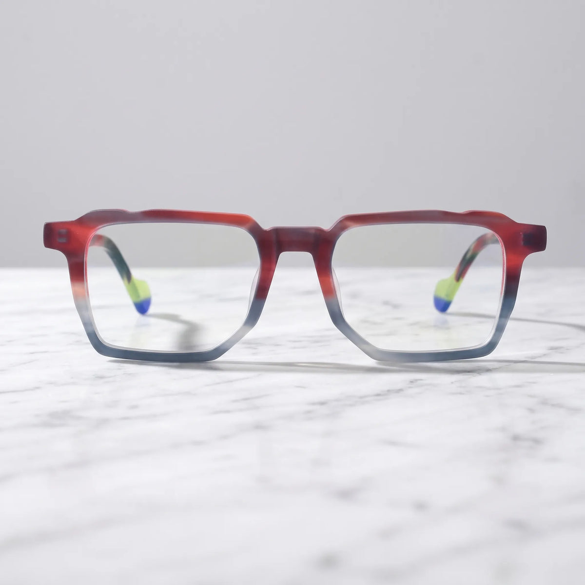 Barledear Crimson Smoke eyeglasses shown in a clean lifestyle setting with a red and gray geometric frame