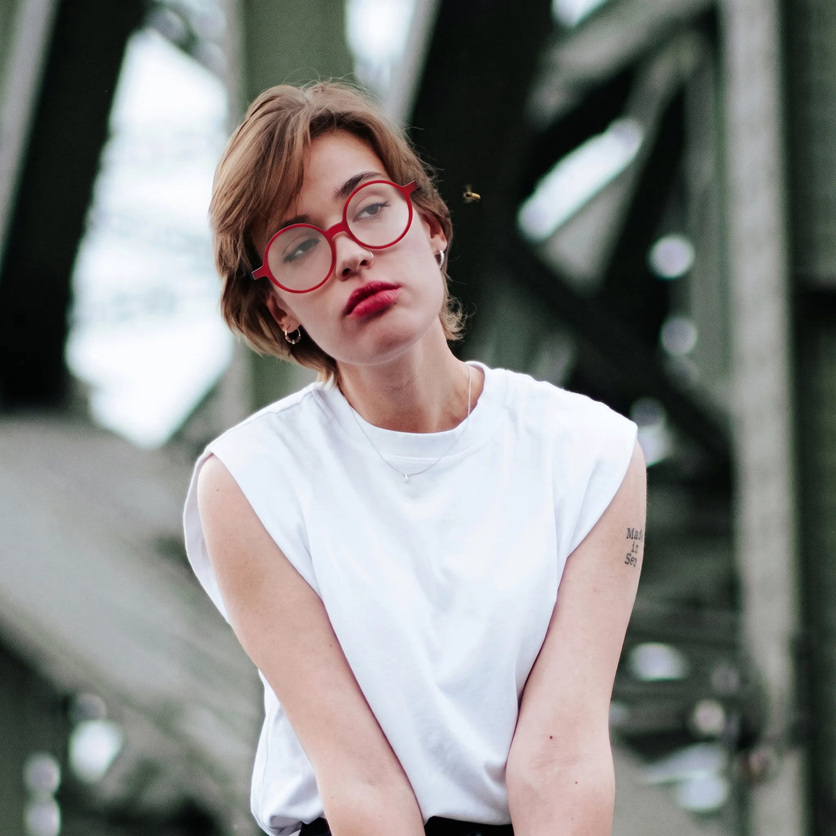 Model wearing Barledear Frosted Ruby Teal round acetate eyeglasses in a lifestyle portrait showing the lightweight frosted frame fit