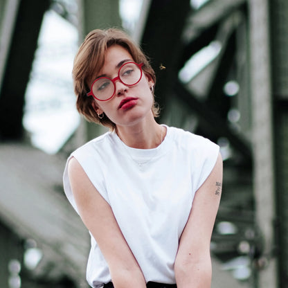 Model wearing Barledear Frosted Ruby Teal round acetate eyeglasses in a lifestyle portrait showing the lightweight frosted frame fit