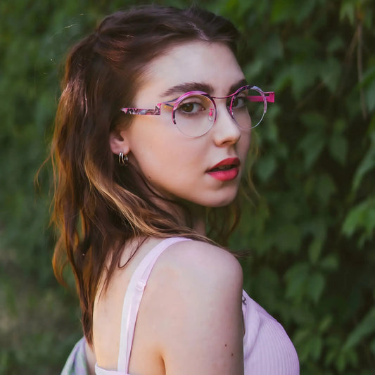 Model wearing Barledear Fuchsia Marble eyeglasses in a lifestyle portrait showing retro round semi-rimless titanium frame style
