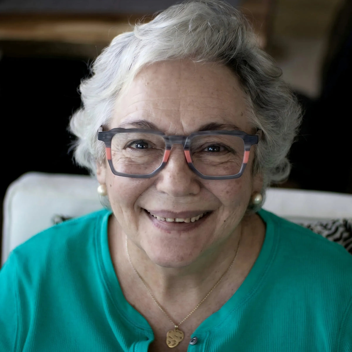 Model wearing Barledear Graphite Blush gray and coral square acetate eyeglasses in a modern lifestyle portrait