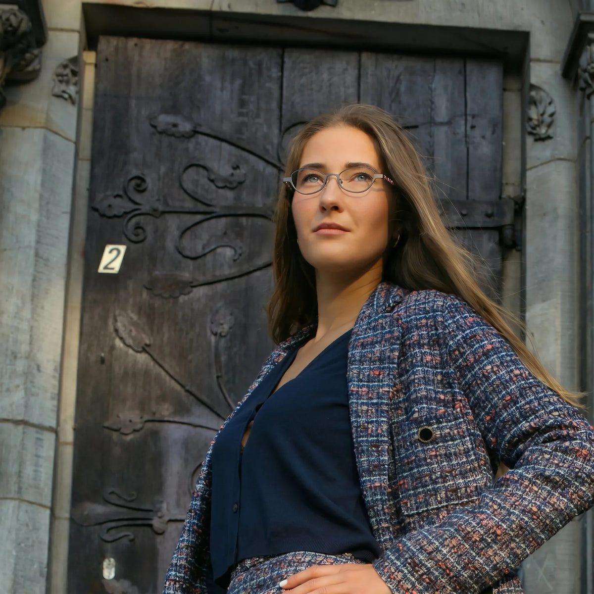 Model wearing Barledear Graphite Tortoise oval titanium eyeglasses in a lifestyle portrait