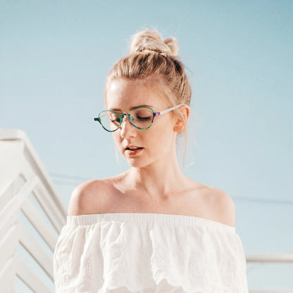 Model wearing Barledear Meadow Jade oval titanium eyeglasses in a lifestyle portrait