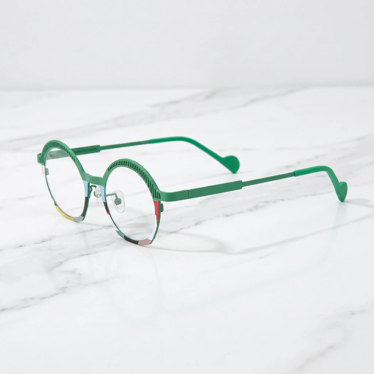 Barledear Meadow Mosaic eyeglasses angled side view showing slim titanium temples, curved green temple tips, and full-rim oval design