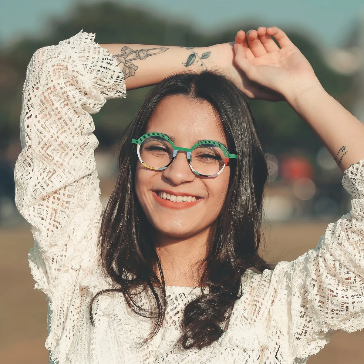 Model wearing Barledear Meadow Mosaic eyeglasses in a lifestyle portrait with green artistic titanium frame styling