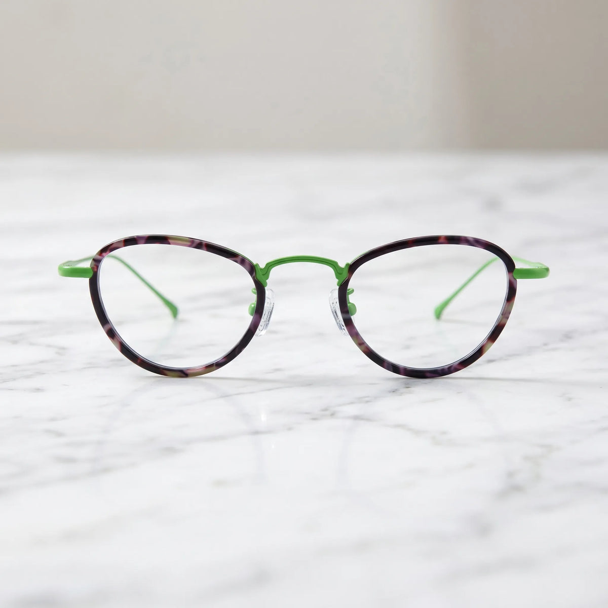 Barledear Meadow Violet eyeglasses shown in a clean lifestyle front view with violet patterned acetate and green titanium details