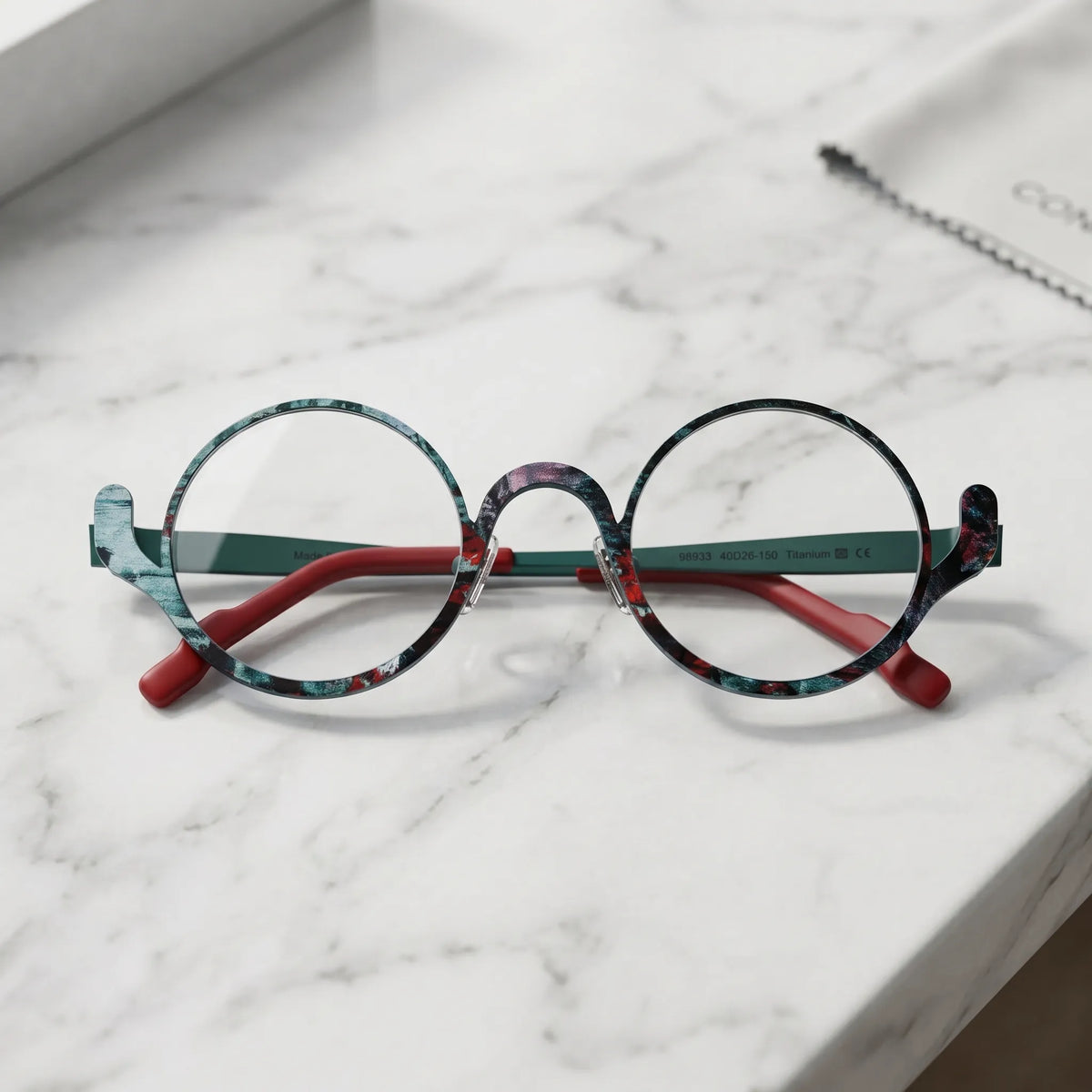 Barledear Mosaic Jade eyeglasses folded display showing the round frame shape, slim temples, and artistic color-spliced pure titanium construction