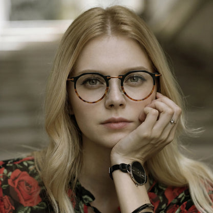 Model wearing Barledear Noir Amber eyeglasses in a lifestyle portrait showing the retro oval acetate metal frame