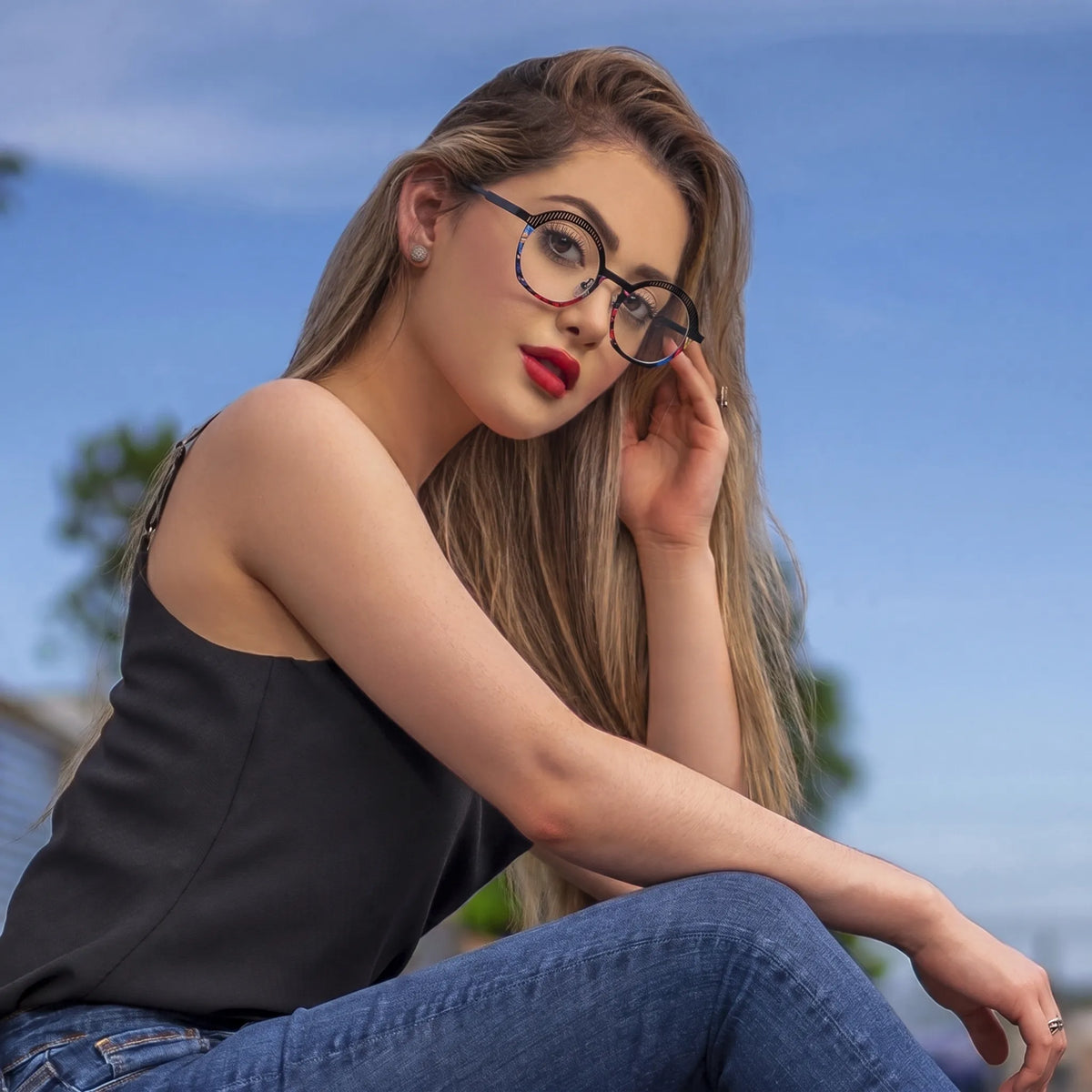 Model wearing Barledear Prism Noir eyeglasses in a lifestyle portrait with black titanium frame and colorful artistic rim accents