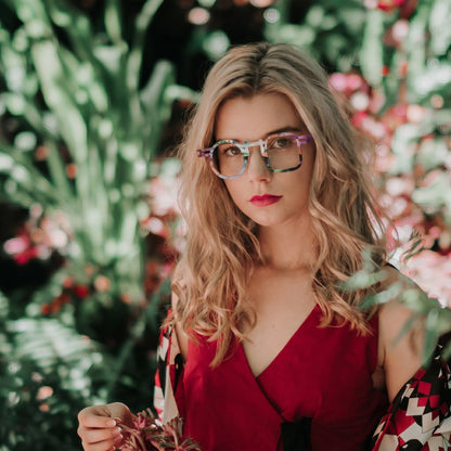 Model wearing Barledear Prism Violet eyeglasses in a lifestyle portrait with asymmetric geometric titanium frame