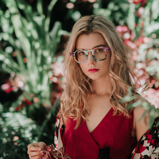 Model wearing Barledear Prism Violet eyeglasses in a lifestyle portrait with asymmetric geometric titanium frame