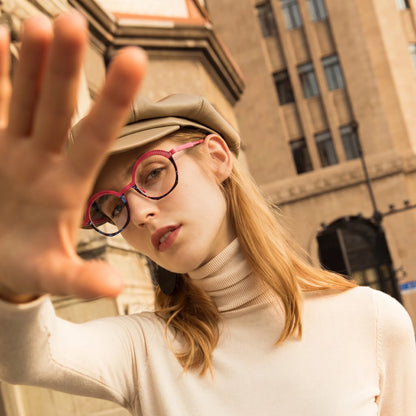 Model wearing Barledear Rose Mosaic eyeglasses in a lifestyle portrait with playful pink geometric titanium frame
