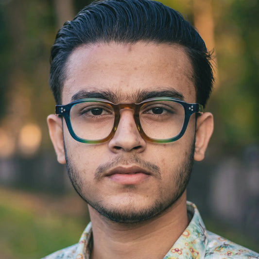 model wearing Barledear Teal Grove eyeglasses in a lifestyle portrait with retro square acetate frame