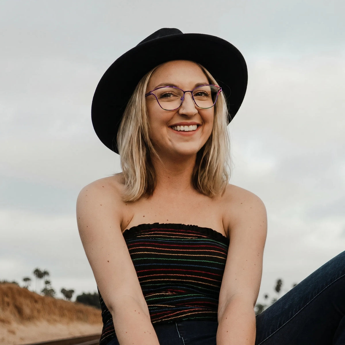 Model wearing Barledear Violet Noir eyeglasses in a lifestyle portrait showing lightweight butterfly cat-eye styling