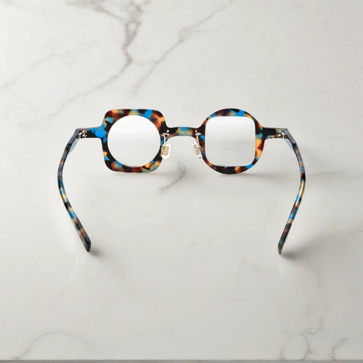 Back view highlighting the blue tortoise colorway of VoyueLens asymmetrical glasses with comfortable silicone pads and sturdy hinges.