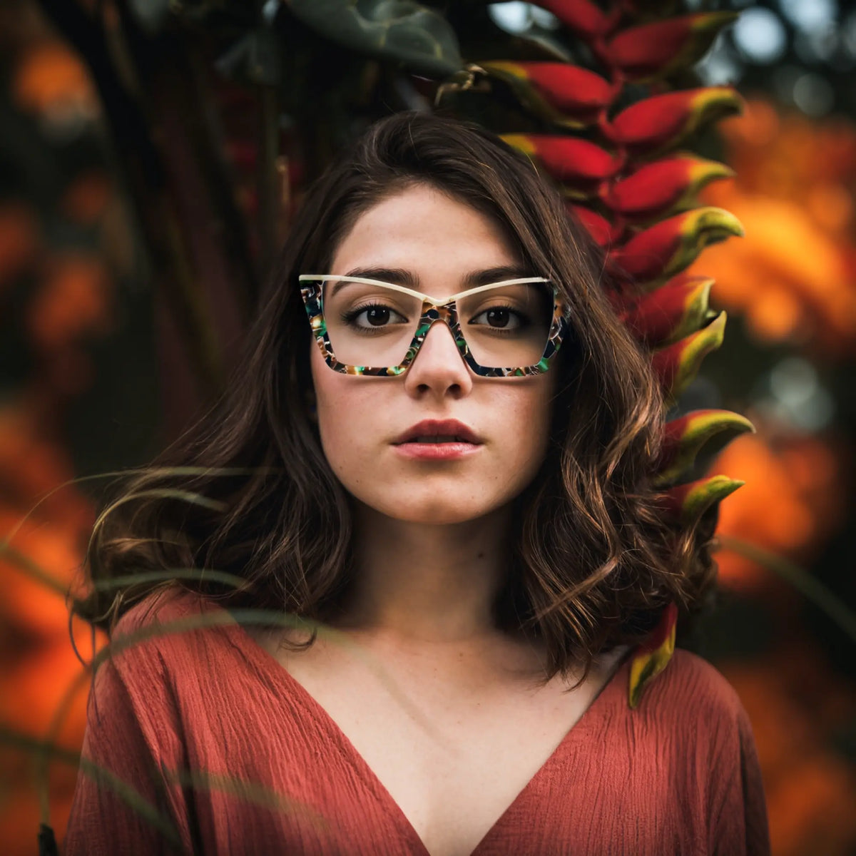 A young woman wearing Olive Tortoise VoyueLens oversized cat-eye glasses, styled in a natural setting to reflect earthy, vintage-inspired fashion
