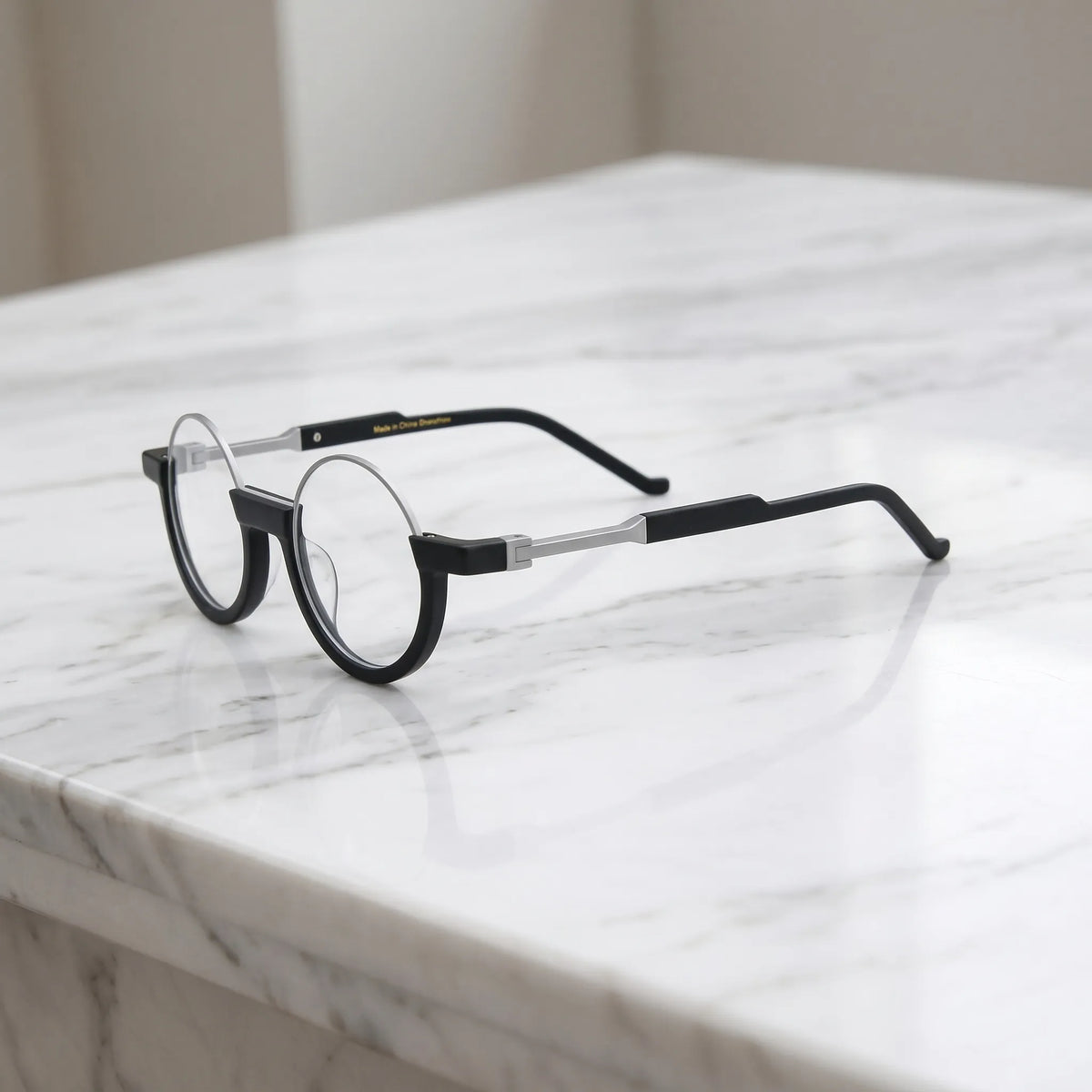 Side profile highlighting the silver-toned bridge and sharp black temple arms of Charcoal Silver round frames.