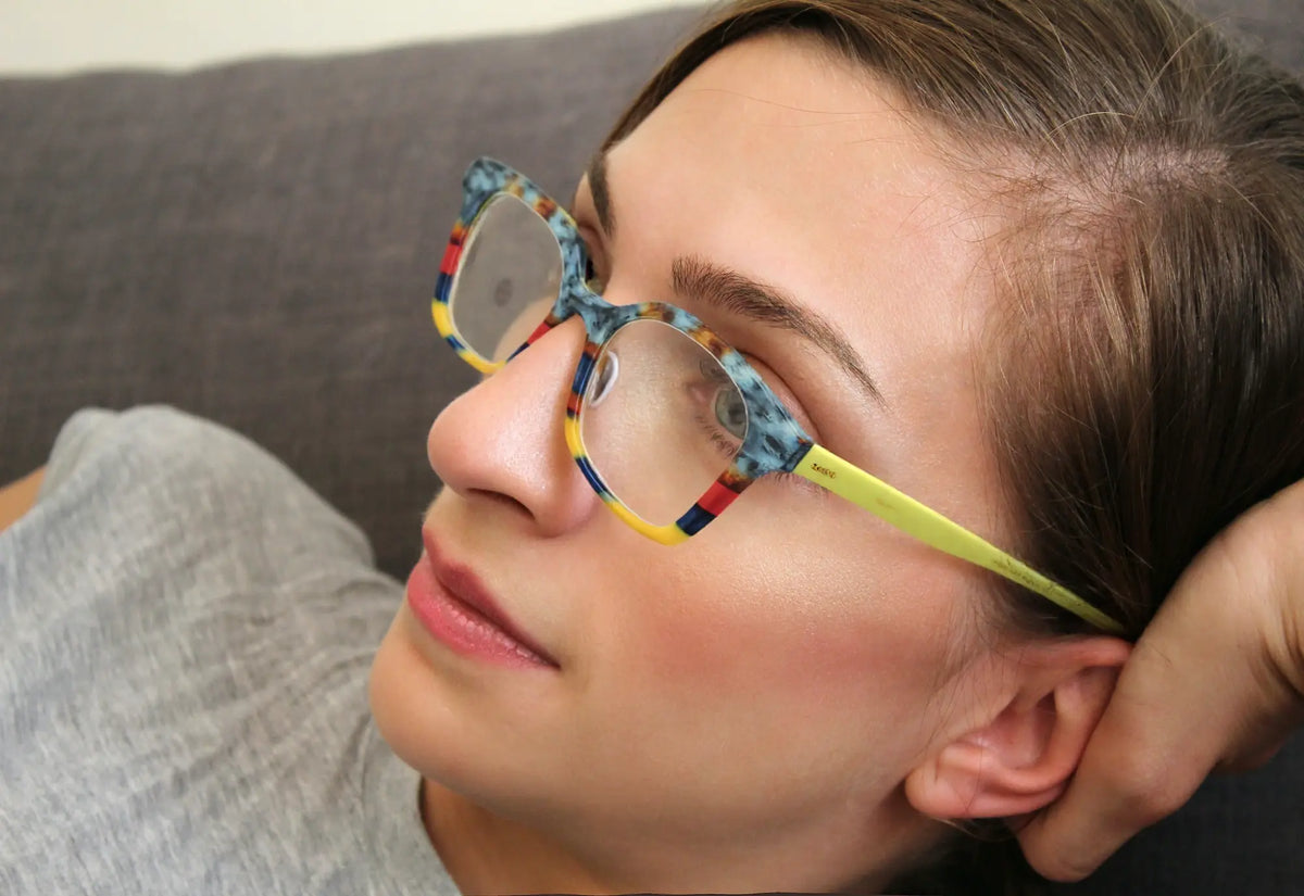 Model wearing VoyueLens Citrus Fade eyeglasses with orange and yellow matte block pattern