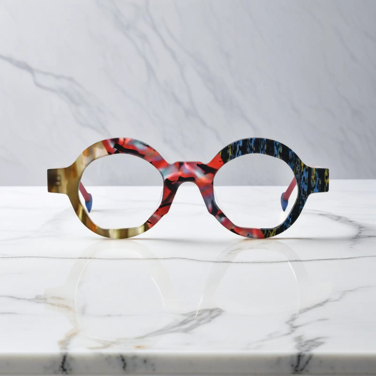 Front-facing image of Crimson Nebula polygon eyeglasses by VoyueLens, swirling red matte finish with bold artistic lines