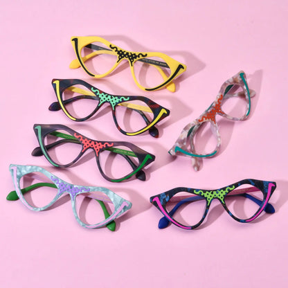 Group shot of six VoyueLens Retro Pixel Cat-Eye Glasses in assorted colors including Cyber Yellow, Color Burst, Jungle Moss, Mint Sorbet, Blush Marble, and Neon Pop displayed on a pastel pink background.