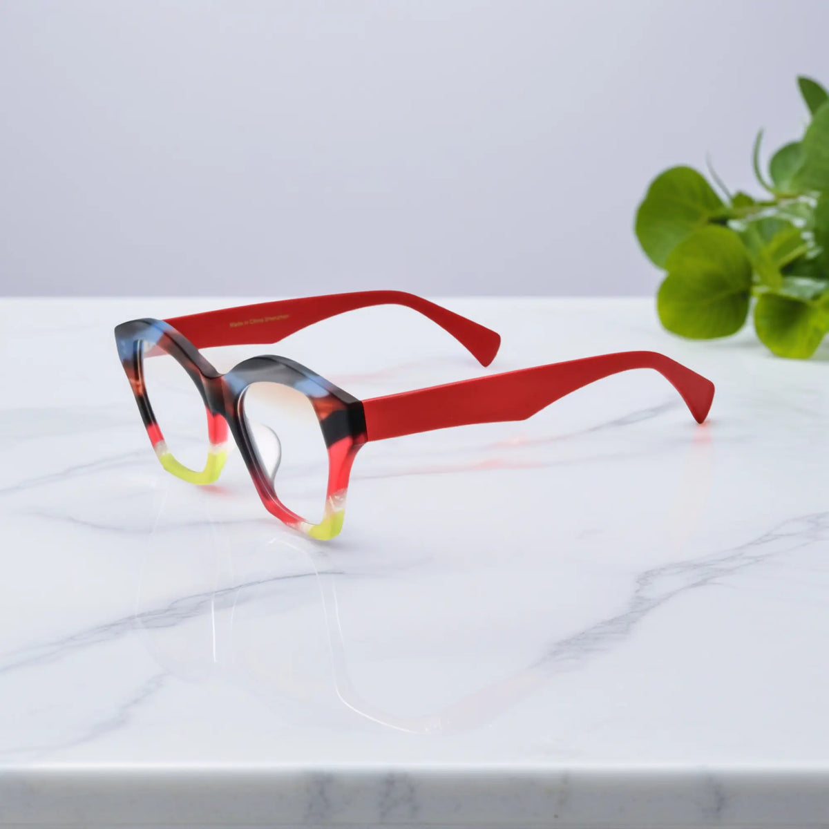 Side view of VoyueLens Rainbow Flame eyeglass frame in orange-red matte acetate with sleek curved arms.