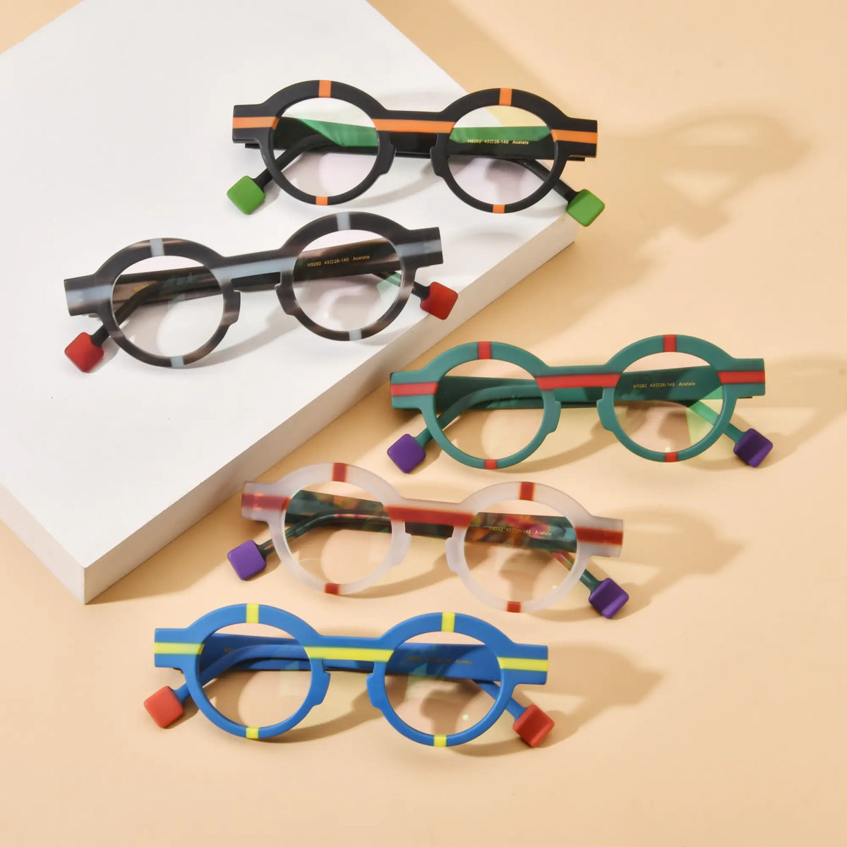 Flat lay display of VoyueLens Retro Geometric Round Glasses in five unique colorways, highlighting bold round acetate frames with matte finishes.
