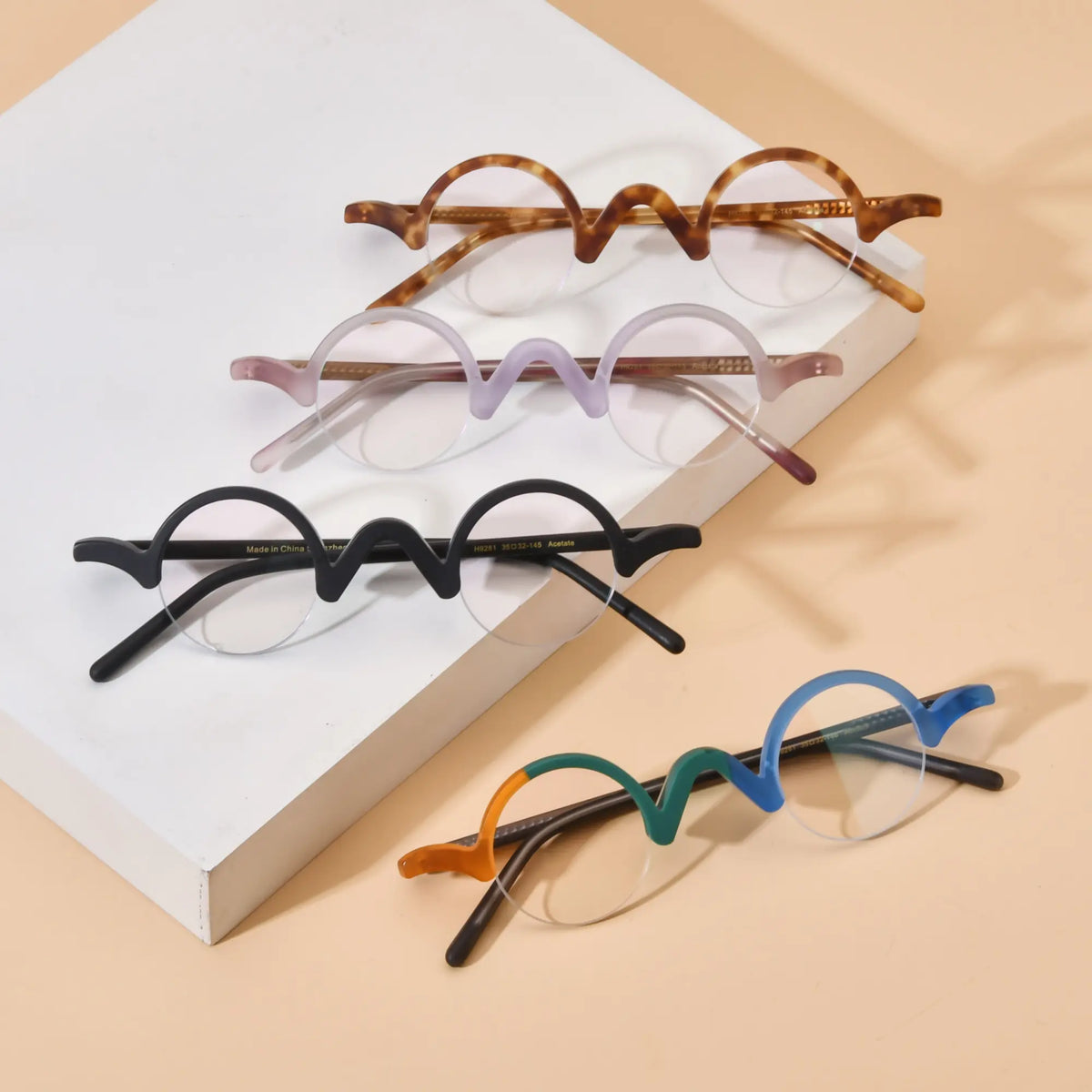 Group display of VoyueLens semi-rimless browline eyeglasses featuring Tortoiseshell, Lilac-Rose, Solid Black, and Teal-Blue color variants on beige background, highlighting wave top design and matte acetate frames.