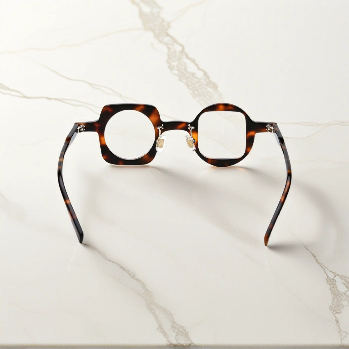 Back view of VoyueLens tortoise asymmetrical glasses with polished acetate finish, silicone nose pads, and durable standard metal hinges.