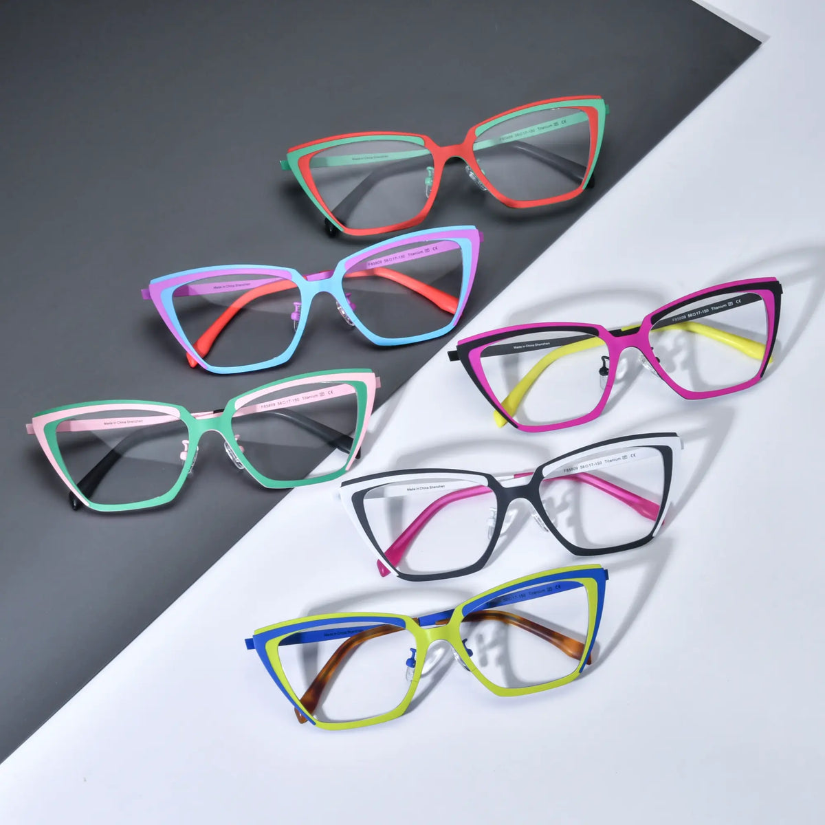 Group shot of VoyueLens VL185809 cat-eye titanium glasses in six dual-tone color options, showcasing bold geometric frames on a black and white background.