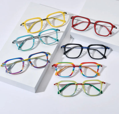 Stylish flat lay composition showcasing the full color range of VoyueLens VL185843 Urban Vision eyeglasses. Includes all seven vibrant variants: Sunshine Yellow, Crimson Alloy, Glacier Teal, Midnight Graphite, Vivid Violet Stripe, Rainbow Parade, and Citrus Mist — arranged aesthetically on staggered white platforms, highlighting the modern square design and titanium detailing.
