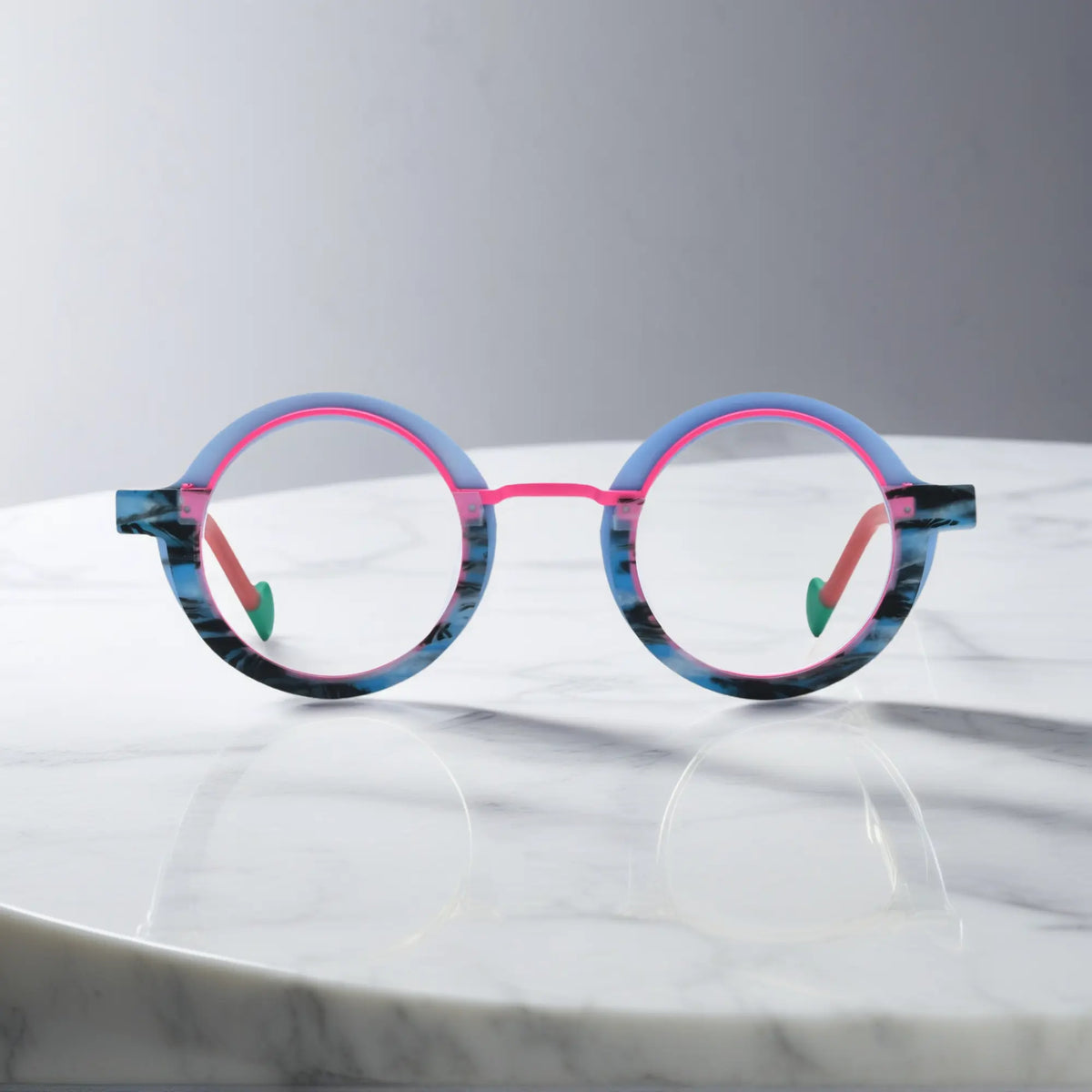 Front view of VoyueLens Chromatic Orbit Eyeglasses in Blue Coral showcasing its bold round silhouette and vibrant color scheme.