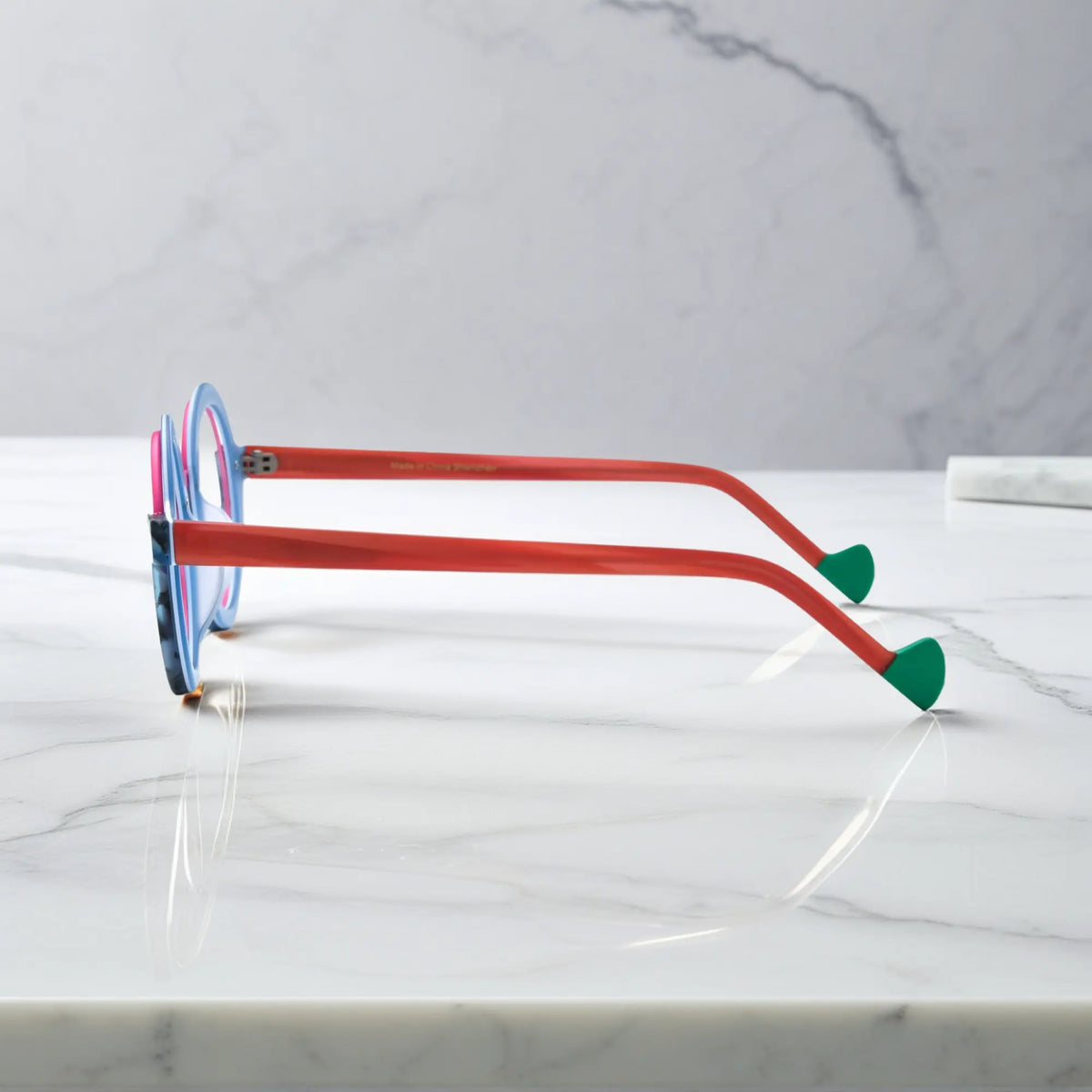 Side profile of VoyueLens eyeglass frames in Blue Coral highlighting temple structure and artistic design.