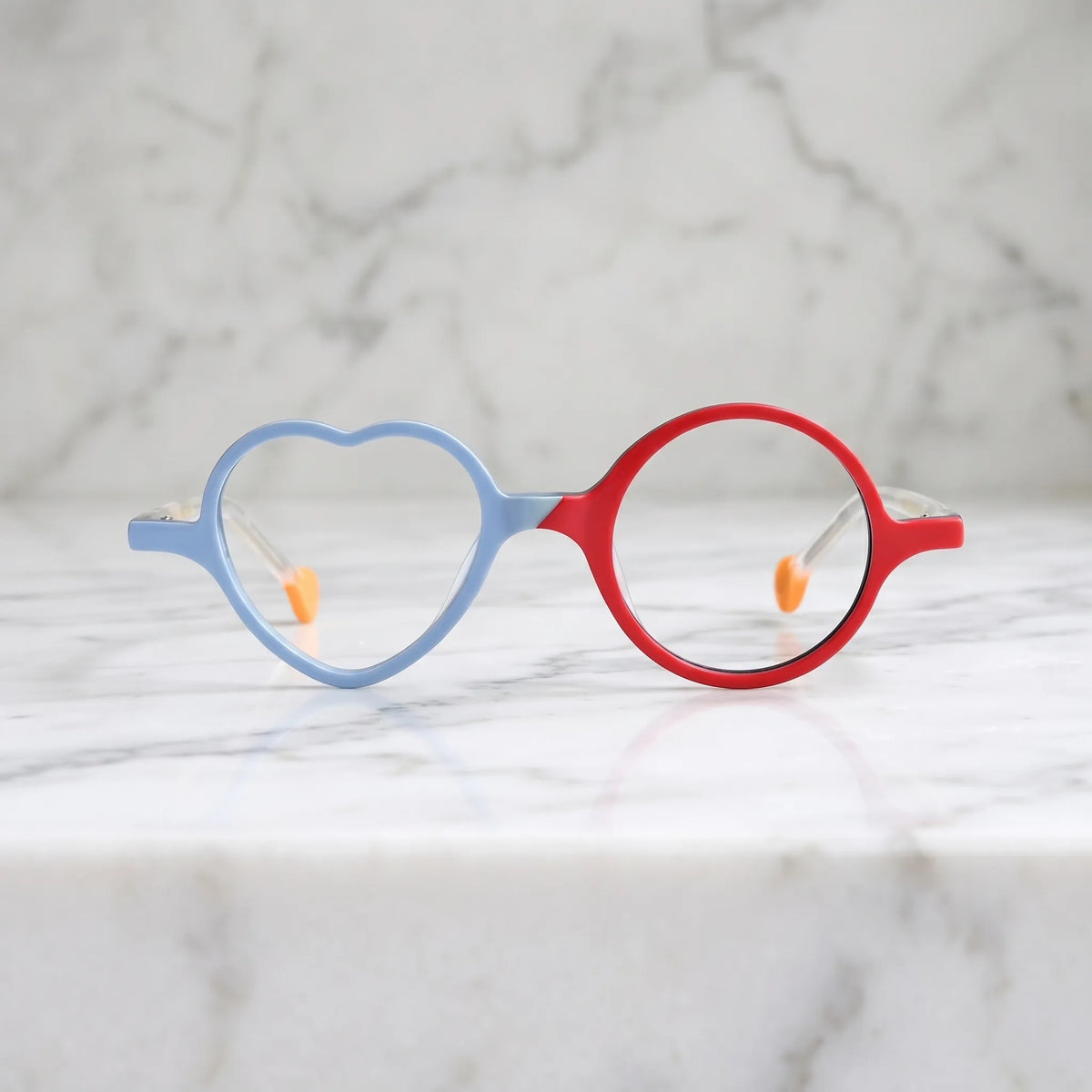 Front view of VoyueLens VL19377 in Ice Blue Cherry, highlighting heart and round lens design. Cool-toned ice blue paired with a cherry red accent in playful shape.